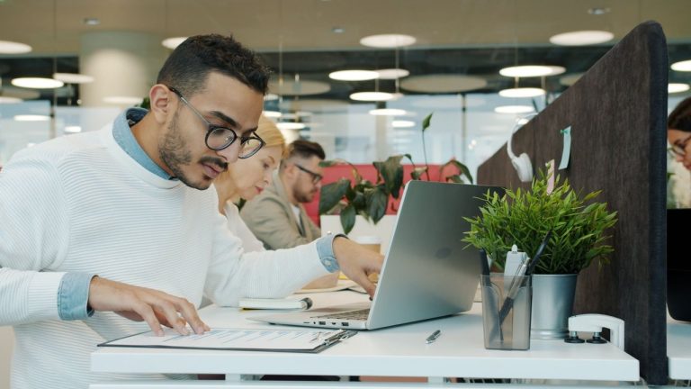 Equipe diversa de profissionais trabalhando em um escritório moderno.