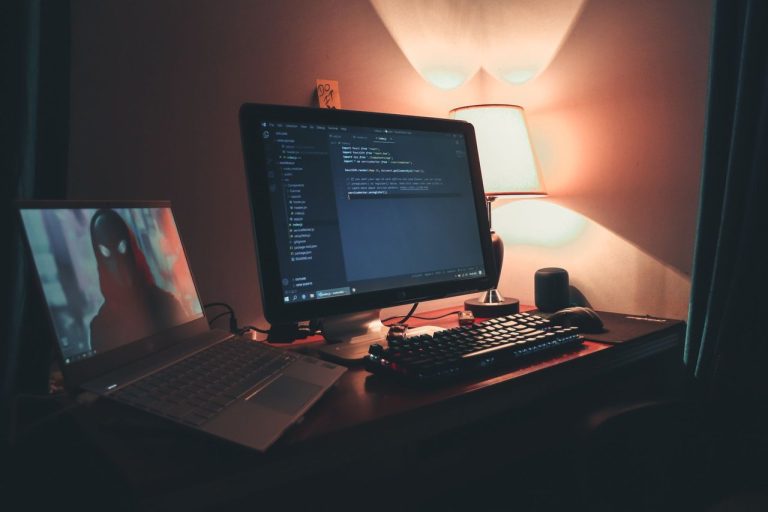 Brasil regulamenta indústria de games e lança plataforma Game Brasil Escritório doméstico com duas telas acesas em uma estação de trabalho usada para programação.